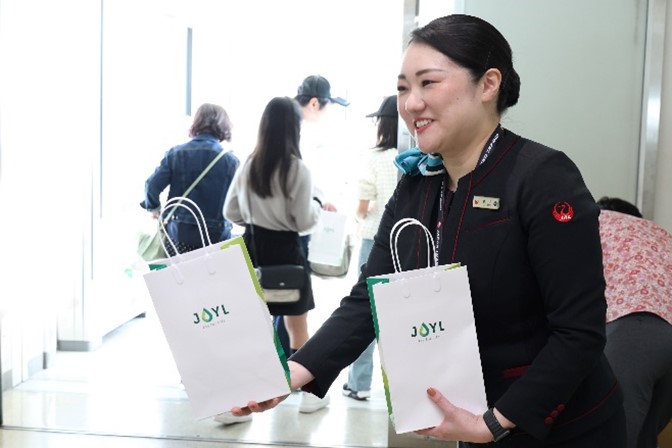 搭乗ゲートでは乗客に記念品を配布している様子
